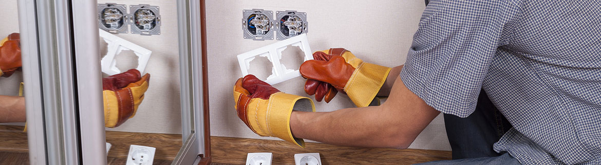 Electrician installs paired socket on the wall